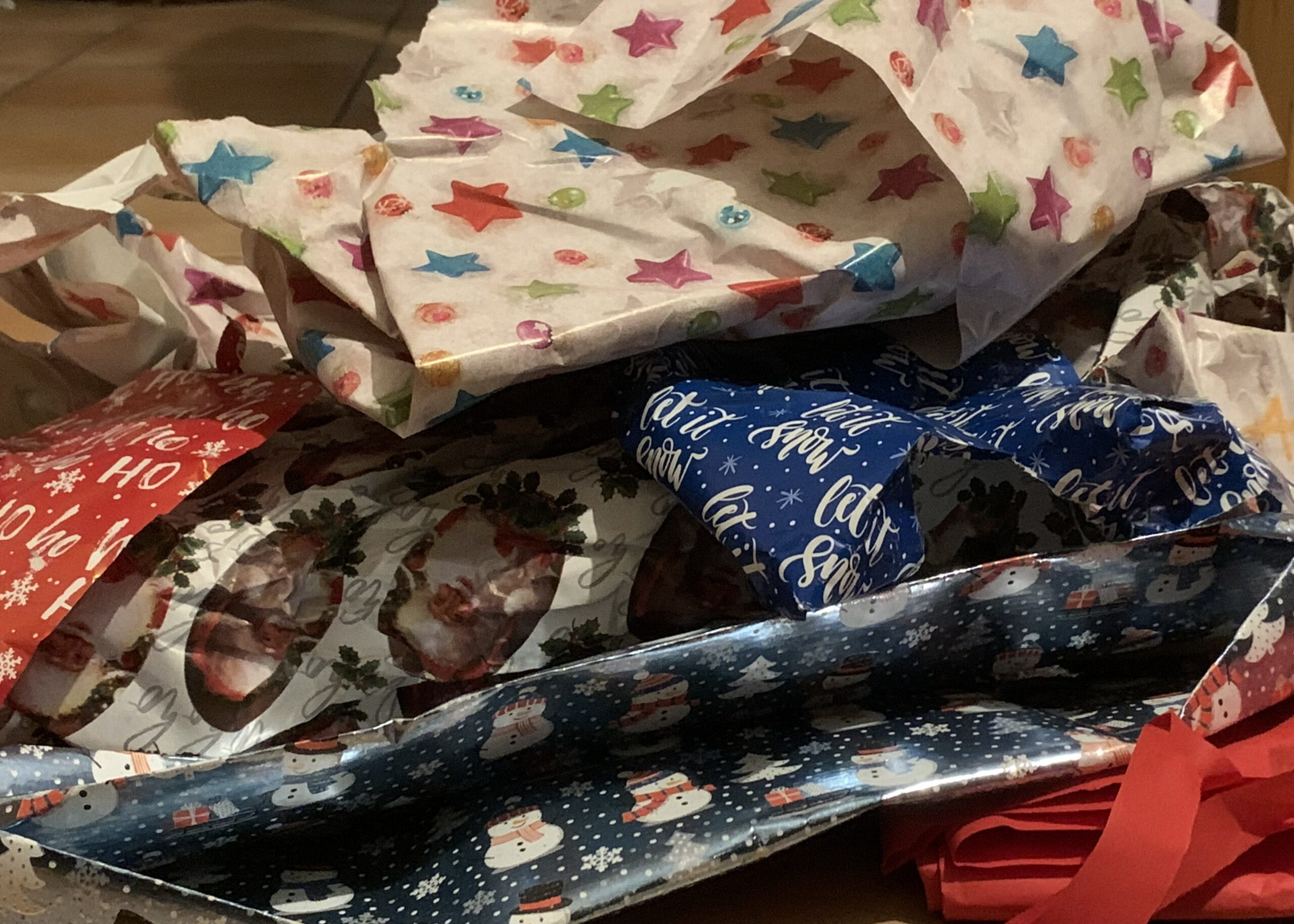 Verschiedene Sorten mit benutztem Geschenkpapier mit verschiedenen Farben, Mustern und Weihnachtdekoration